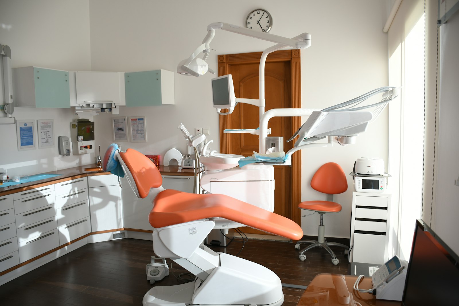 Empty dental operatory with chair, delivery unit and a computer terminal