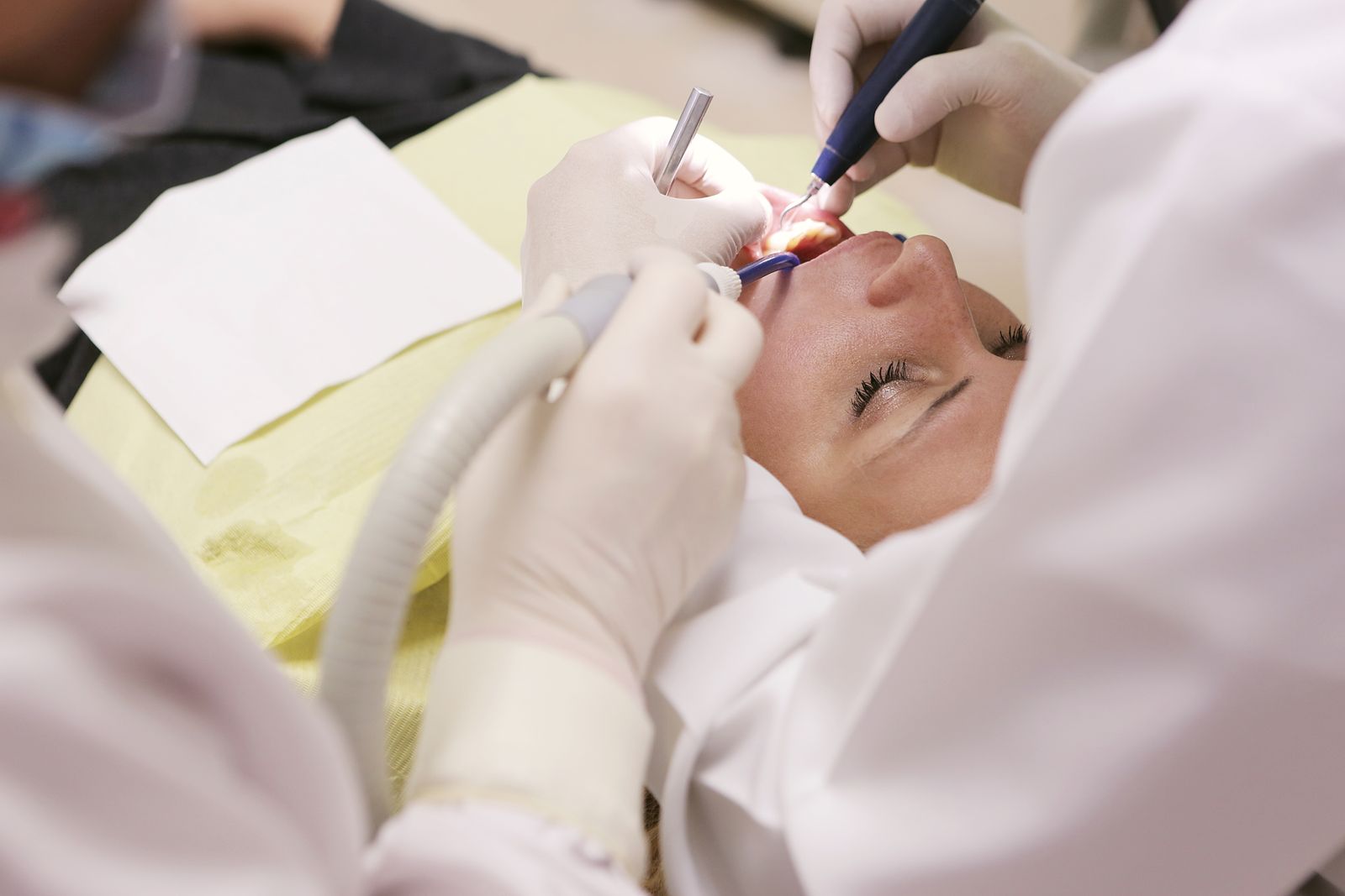 Dentist treating a patient with a handpiece in a clinical setting